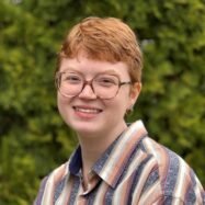 Woman with striped shirt looks at camera.