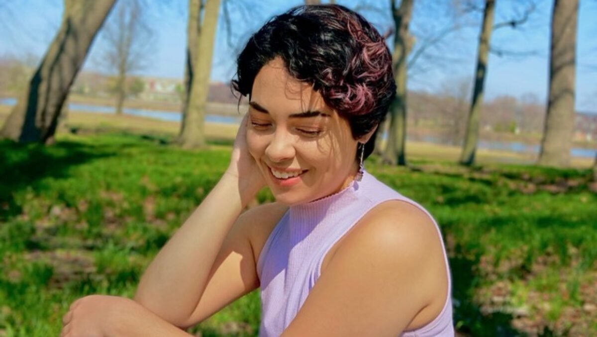 Dina Folgia Woman in purple shirt looks off camera