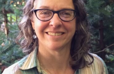 Woman in striped shirt smiles at camera