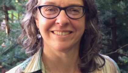 Woman in striped shirt smiles at camera