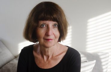 Woman with short dark bob and black shirt looks at the camera.