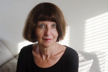 Woman with short dark bob and black shirt looks at the camera.