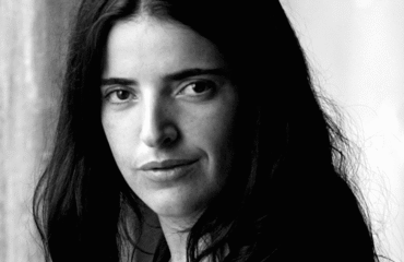 Black and white photo of a woman with dark hair, looking at the camera.