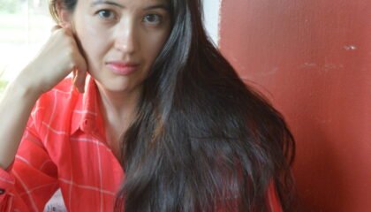 Woman in a red dress stares at the camera